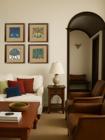 A set of four framed panels featuring the 'Tree of Life' motif, with two depicting celestial angels and two with peacocks, displayed in a room with a white sofa, wooden furniture, and a traditional decor.